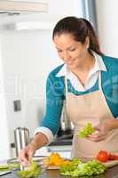 Smiling woman making salad vegetables kitchen preparing