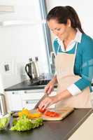 Happy woman cutting tomato kitchen preparing salad