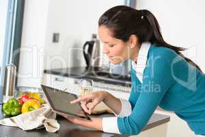 Young woman reading recipe tablet kitchen searching