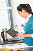 Happy woman looking recipe tablet kitchen reading