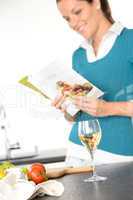Woman reading recipe cooking book kitchen salad