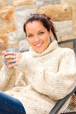 Smiling woman drinking hot cocoa relaxing garden