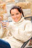 Smiling woman drinking hot cocoa relaxing garden