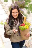 Happy woman shopping phone groceries texting vegetables