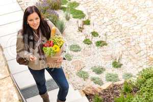 Young woman arriving home groceries shopping smiling