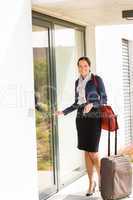 Smiling woman business flight attendant arriving home