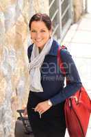 Happy businesswoman arriving home traveling luggage tired