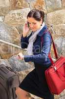 Happy woman calling hurried traveling luggage phone