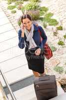 Pretty filght attendant leaving calling luggage phone