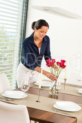 Young woman placing flowers dinner table
