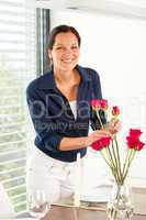Young woman arranging flowers dinner table