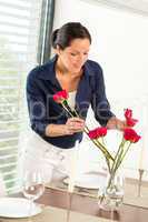 Young woman arranging flowers dinner table