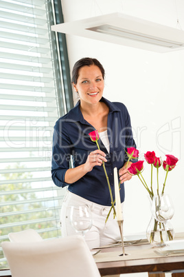 Happy woman putting bouquet dinner table
