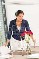 Young woman placing candle table roses romantic