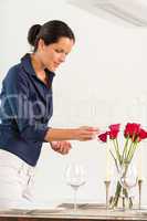 Woman lighting candle dining room Valentine's day