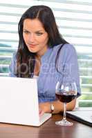 Young businesswoman relaxing home wine surfing internet