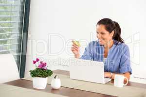 Cheerful woman internet home banking card laptop