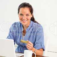 Smiling woman paying bills online banking home