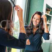 Young woman combing hair comb mirror bathroom