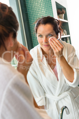 Young woman cleaning face cotton pads bathrobe
