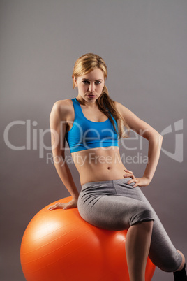 schöne junge sportlerin sitzt auf einem fitness ball