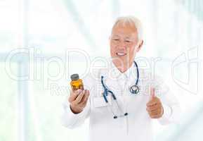 Thumb up Asian doctor holding bottle pills