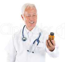 Asian senior doctor holding a bottle of pills