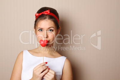 Beautiful young woman holding a red heart