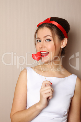 Beautiful young woman holding a red heart