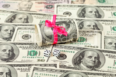 US dollars wrapped by ribbon on money background