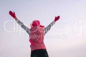 Teen girl staying with raised hands