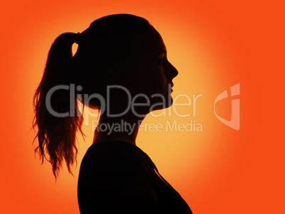 woman portrait profile  in silhouette shadow on studio orange background