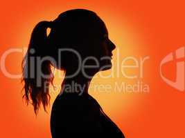 woman portrait profile  in silhouette shadow on studio orange background