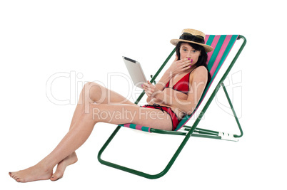 Amazed bikini lady holding tablet