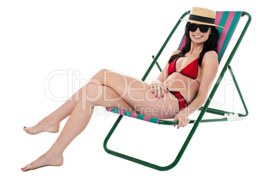 Glamorous bikini model relaxing on reclining chair