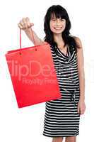 Smiling woman offering bag full of gifts