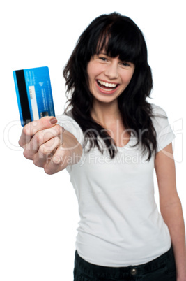 Joyous brunette showing her credit card to you