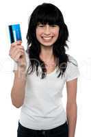 Happy young woman showing credit card