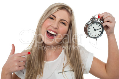 Excited girl holding old fashioned alarm clock
