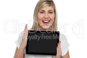 Active caucasian girl displaying tablet device