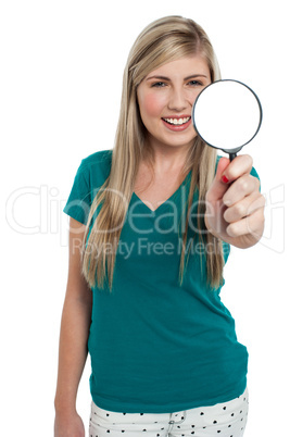 Attractive girl holding magnifying glass