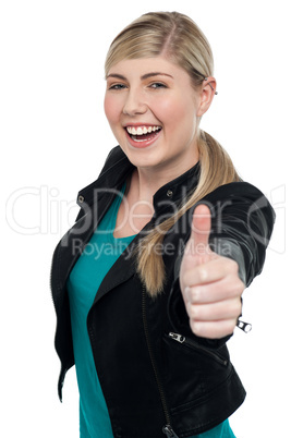 Joyful blonde teen gesturing thumbs up