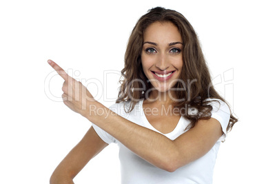 Casual woman pointing towards the copy space