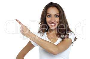 Casual woman pointing towards the copy space