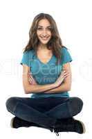 Pretty woman seated on the floor with hands crossed