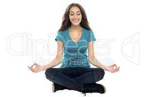 Smiling woman meditating in lotus position