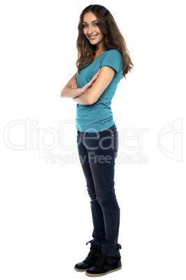 Stylish woman standing sideways with arms crossed