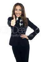 Joyous young stewardess gesturing thumbs up