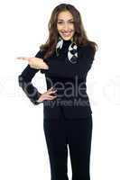 Beautiful air hostess pointing towards right direction