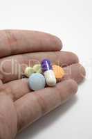 hand holding assorted pills